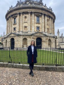 A woman standing in front of an old academic building