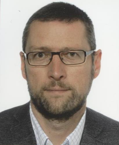 A headshot of a man with glasses