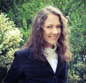 A smiling woman against a garden backdrop