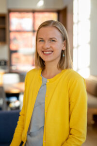 A smiling woman in a yellow sweater