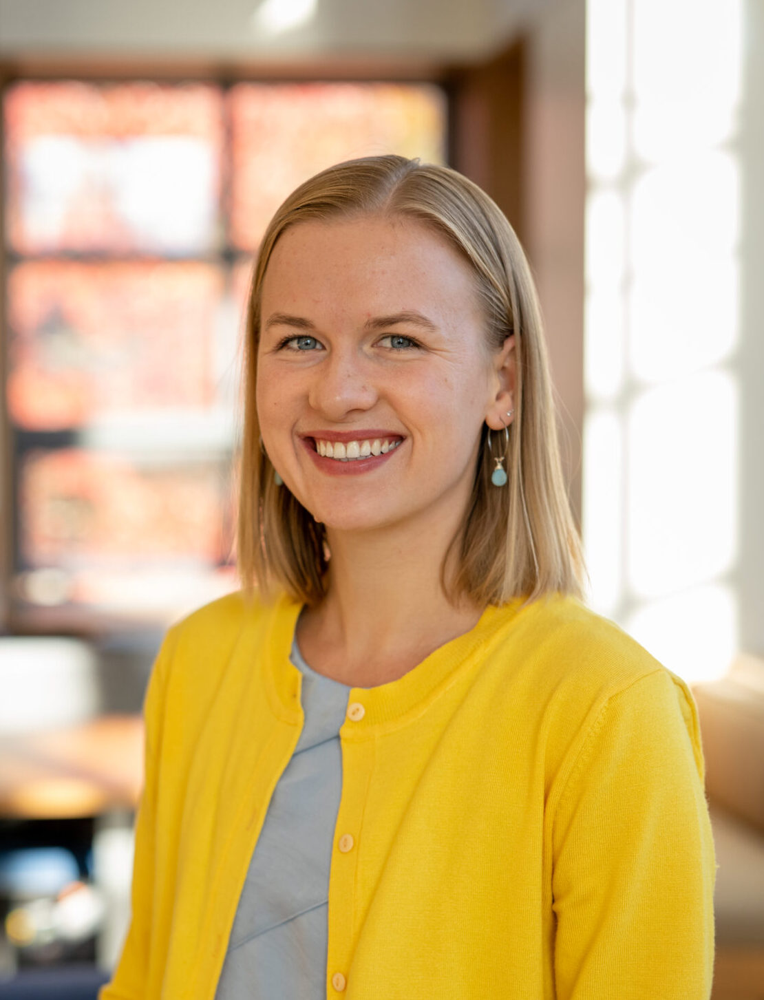 A smiling woman in a yellow sweater