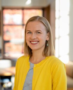 A smiling woman in a yellow cardigan