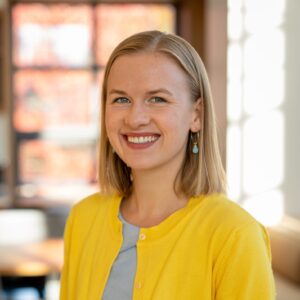DeSisto_Isabelle A smiling woman in a yellow cardigan