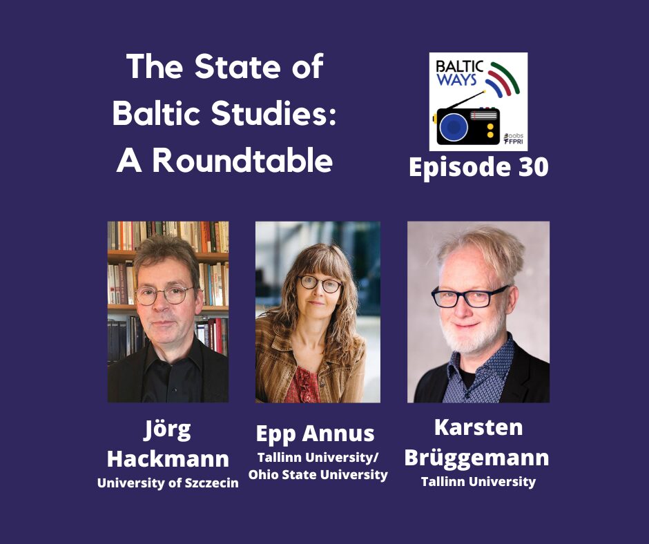 A smiling man wearing a suit