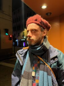 A man in a red hat and multicolored scarf
