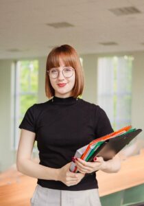 A smiling woman carrying folders